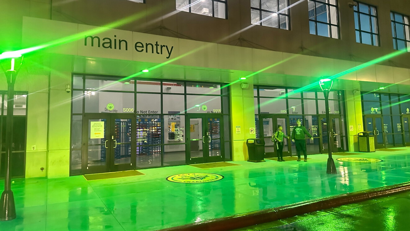 Operation Green Light at HQ2: Amazon building entrance bathed in vibrant green light