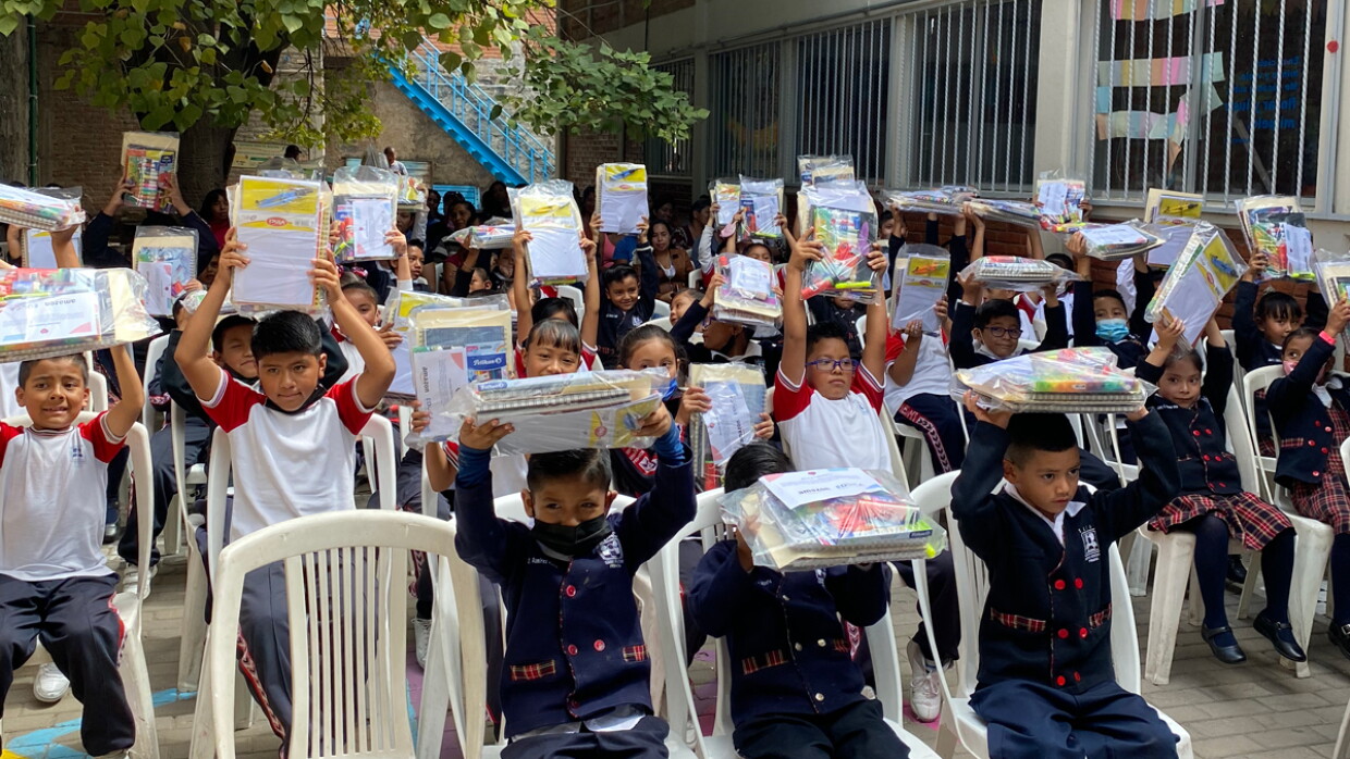 En el patio del colegio, los 50 niños beneficiarios de la alianza entre Amazon y Educando están mostrando los paquetes de material. 