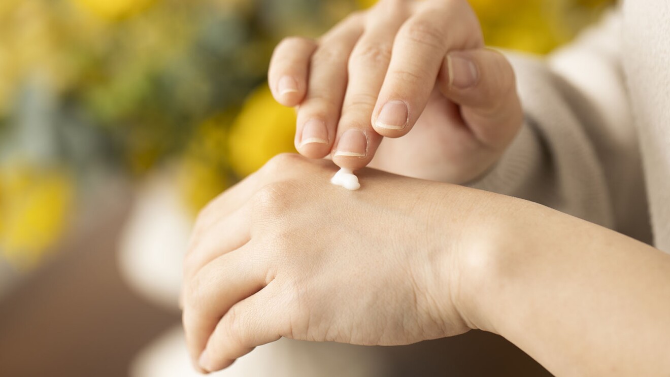 手の甲にクリームを置き、塗り疲労気用途している手