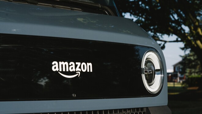 一辆电动送货车的前部细节,显示了亚马逊的标志。