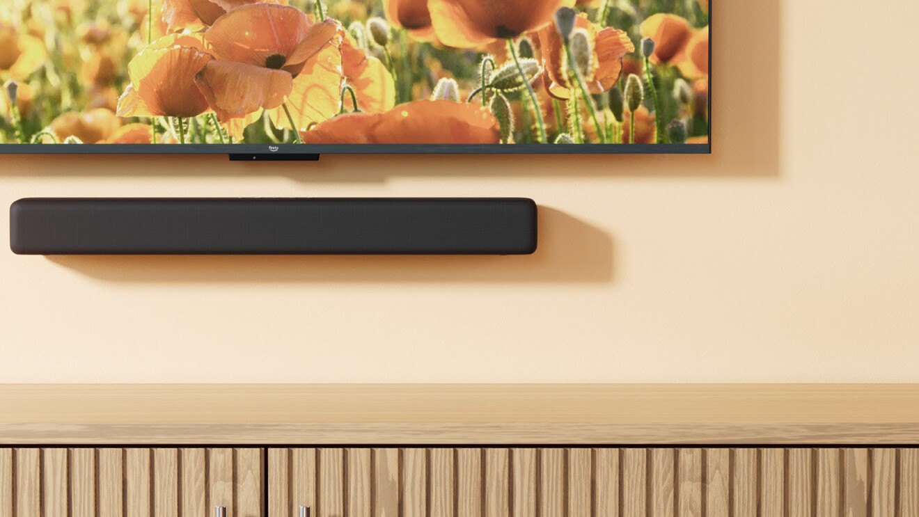 lifestyle image of the fire tv soundbar under a fire TV in a living room setting