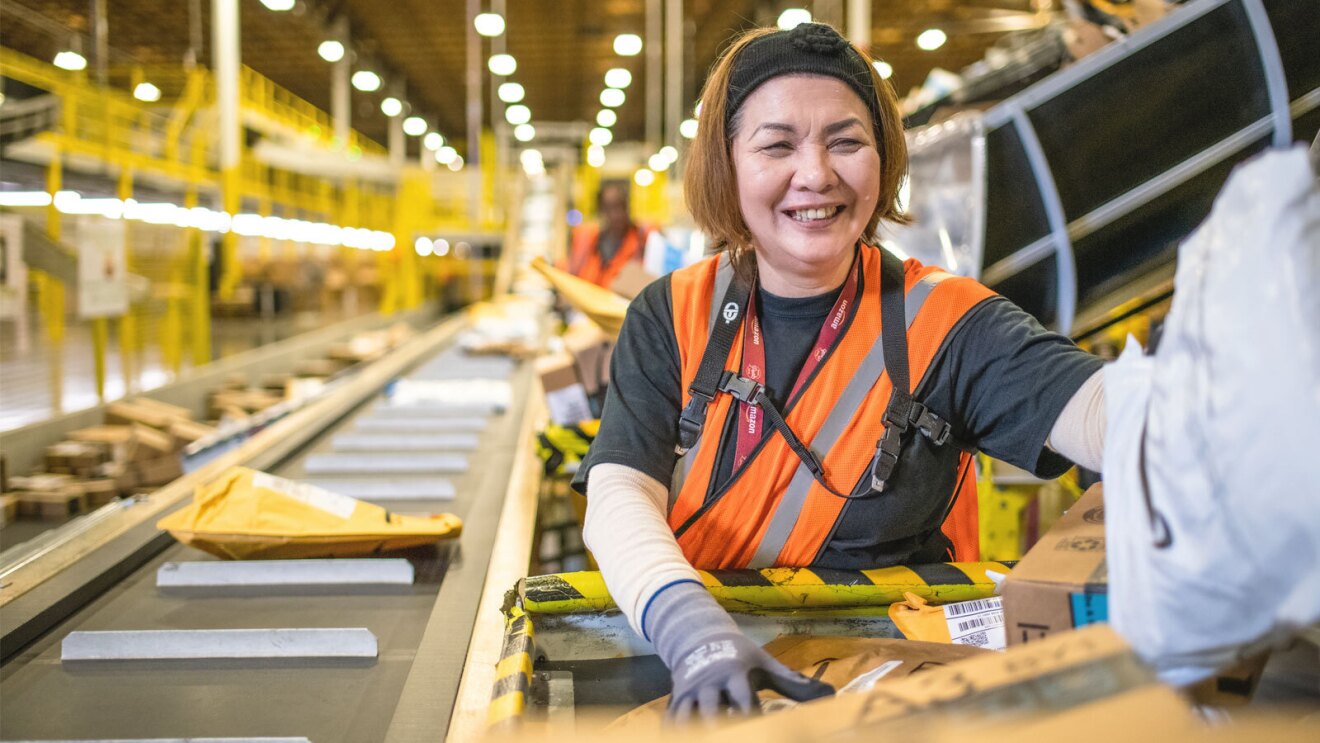 An Amazon operation employee works in a fulfillment center.