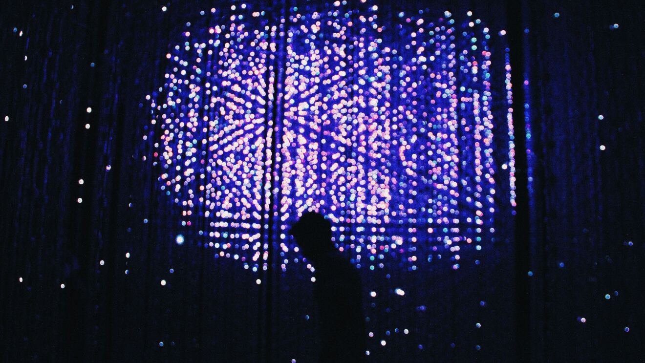 的形象,一个人走在前面的墙灯在晚上