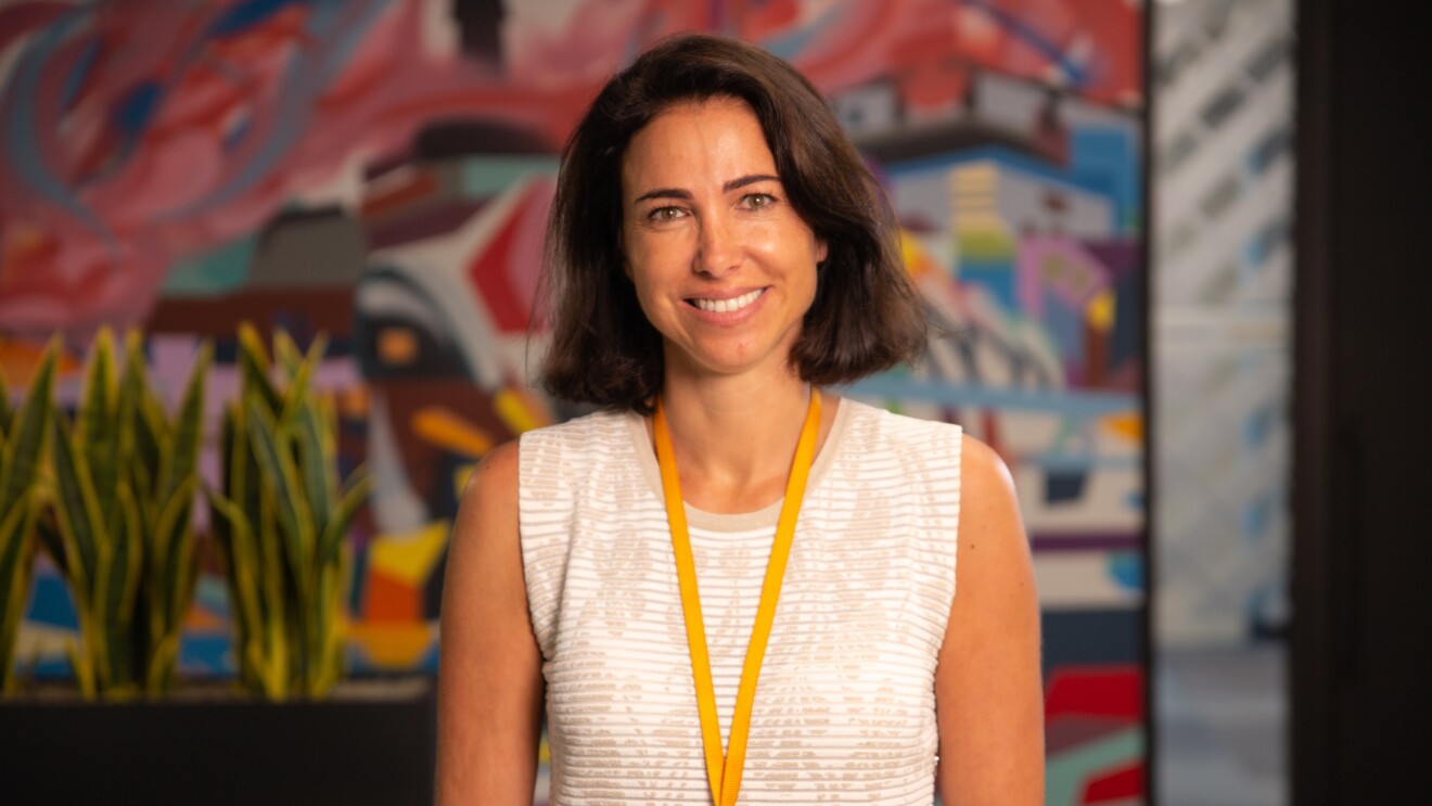 Ruth Díaz, Vicepresidenta de Amazon Fashion en Europa. En las oficinas corporativas de Amazon en Madrid, Ruth aparece en un plano hasta la cintura. Llev amedia melena morena, un jersey blanco con dibujos de flores en beis. Lleva la tarjeta de Amazon en una cadena amarilla de ropa. Con los ojos azules, mira a cámara con una sonrisa.