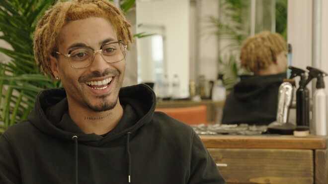 一个人的形象照片坐在椅子上微笑。