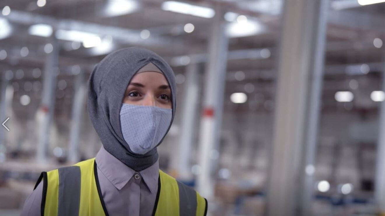 Eine Frau in Kopftuch und Maske.