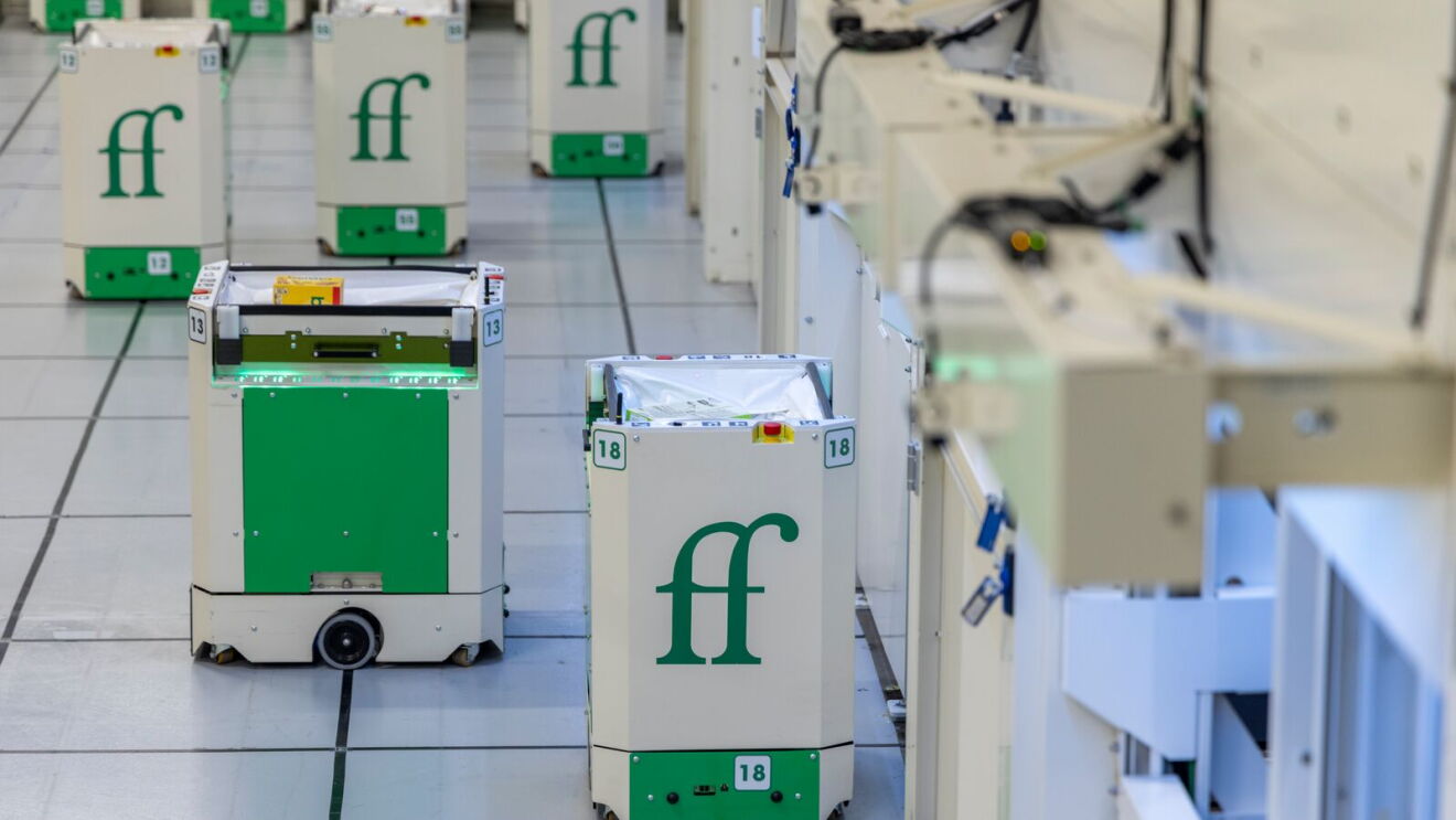Automated robots with 'ff' logo in warehouse-like setting