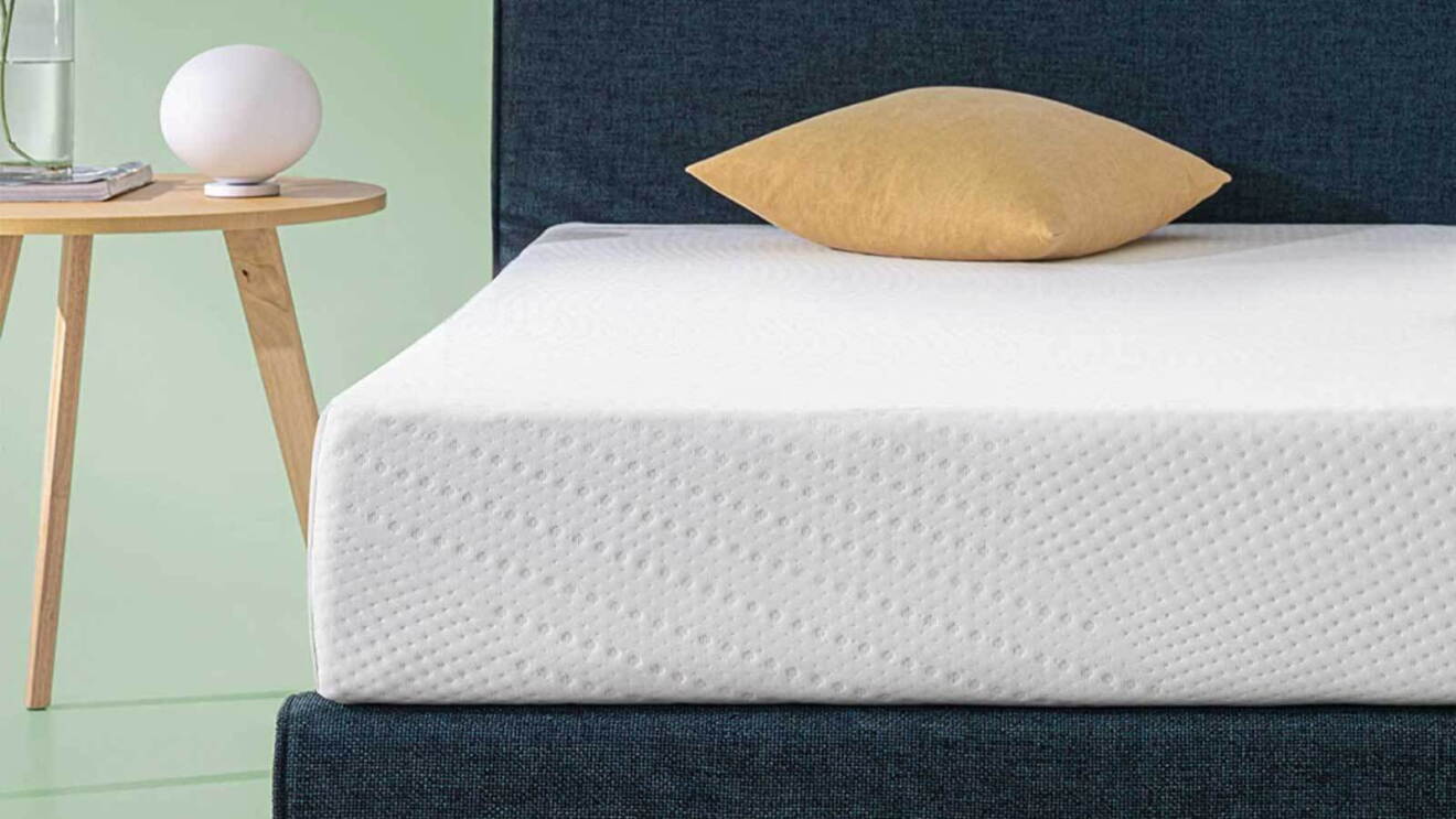 Prime Day 2023 live blog best deals: view of a white mattress with a pillow on top of it next to a nightstand.