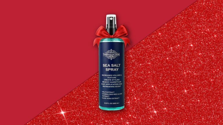 Sea salt spray bottle with red bow on festive red background