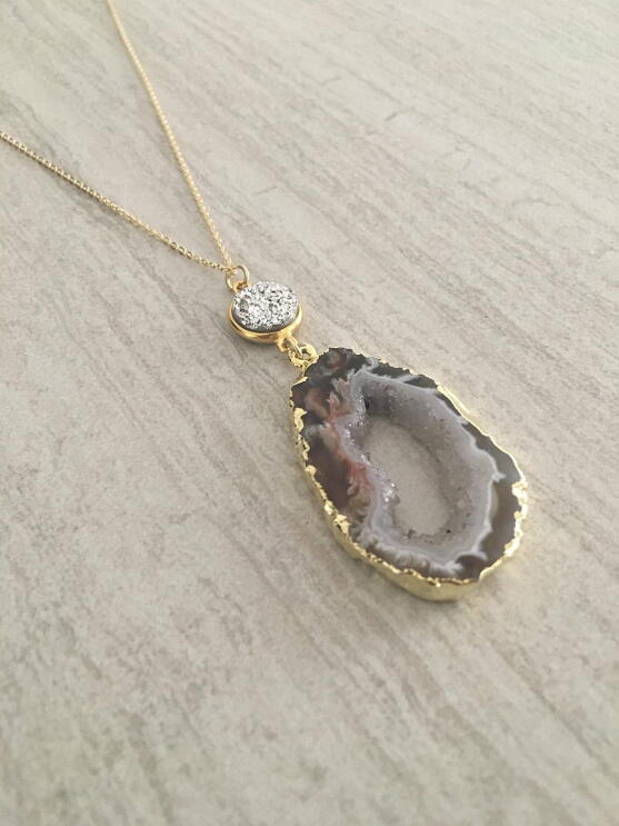 A flat shot of handmade jewelry with raw and semi-precious stones made by T. Victoria.