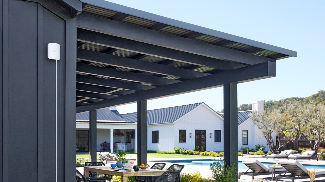 Outdoor living space with black pergola and view of luxury ranch house