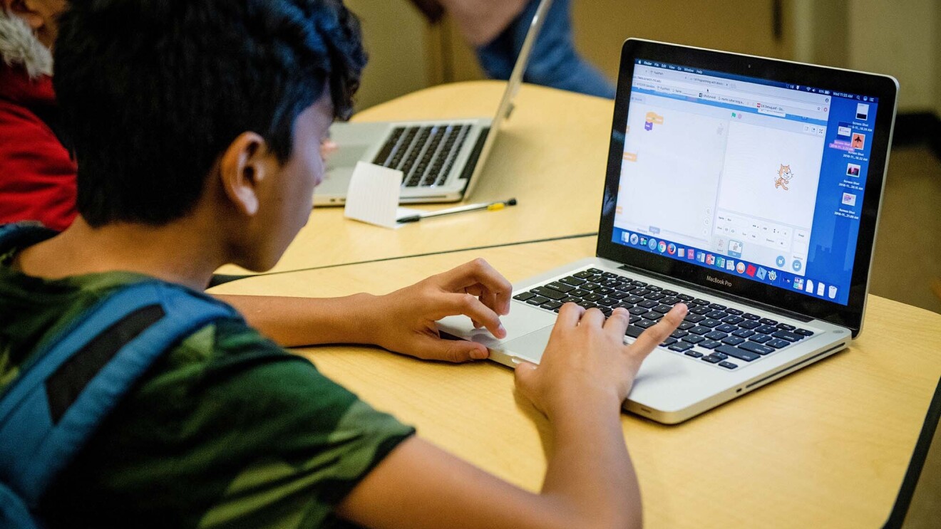 Students work on coding programs on laptop computers in a classroom at a New York City school.