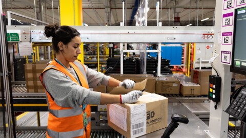 Employee in safety vest processing boxes at distribution center