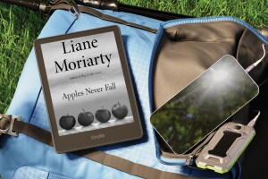 A Kindle open to "Apples Never Fall" by Liane Moriarty