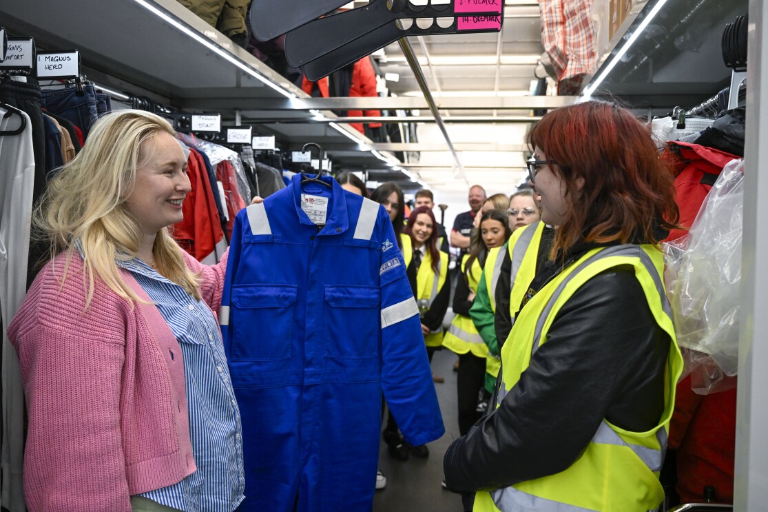 Kate Gill shows students the costumes used on set