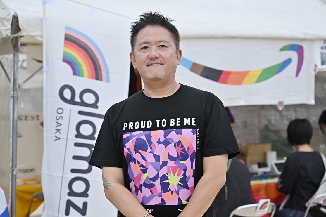 PROUD TO BE MEと書かれた黒いTシャツを着た男性