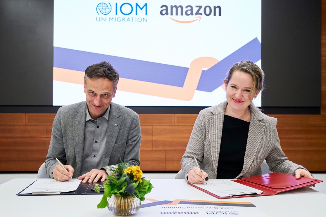 Rocco Bräuniger, Country Manager von Amazon in Deutschland, mit der Vertreterin der Internationalen Organisation für Migration (IOM) bei der Unterzeichnung des gemeinsamen Abkommens zur Katastrophenhilfe.