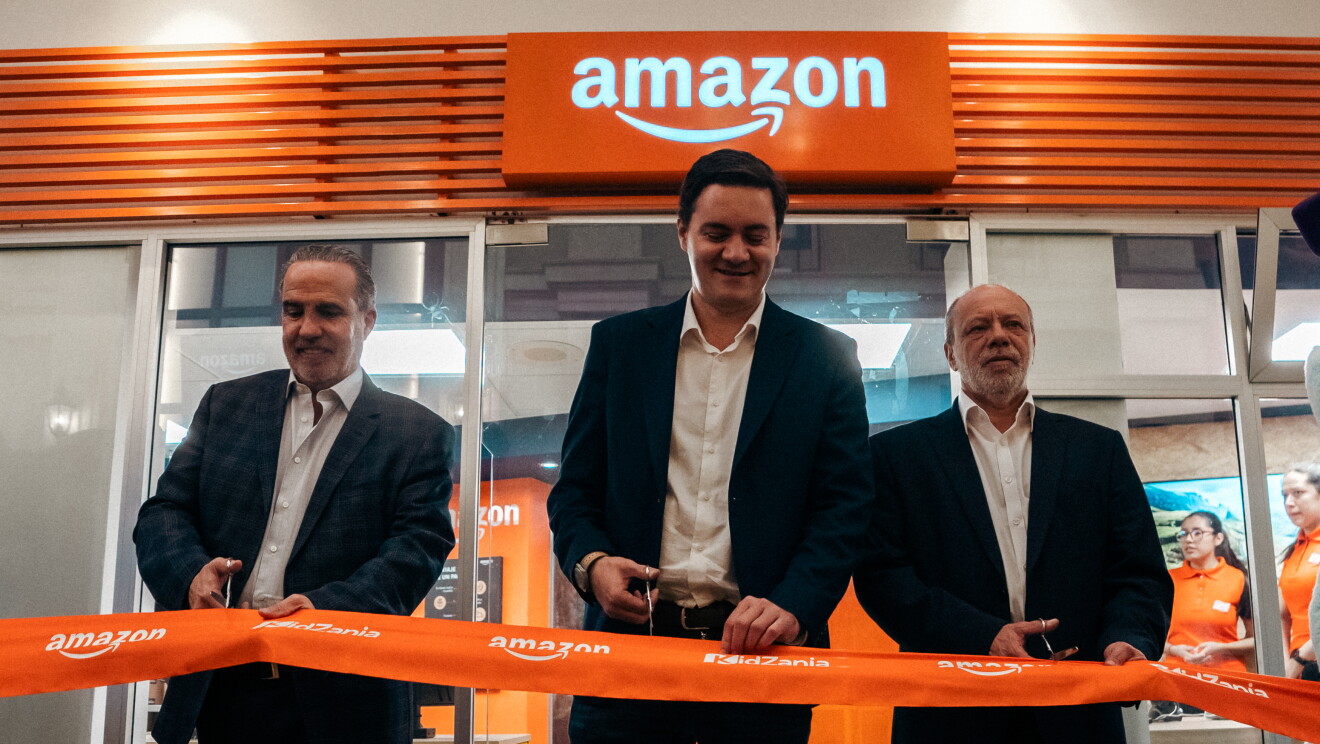 Imagen de tres hombres cortando la banca de Amazon en Kidzania. 