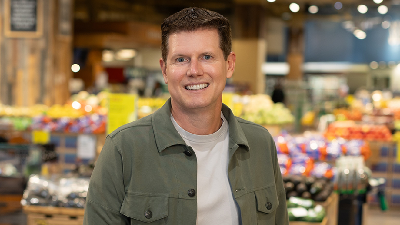 Jason Buechel smiles in the produce section of Whole Foods Market 