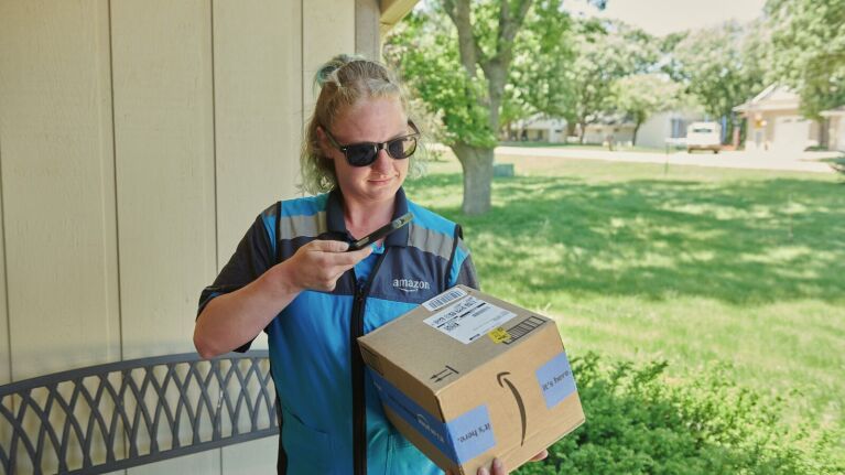 Amazon delivery driver delivers a package to a customer.