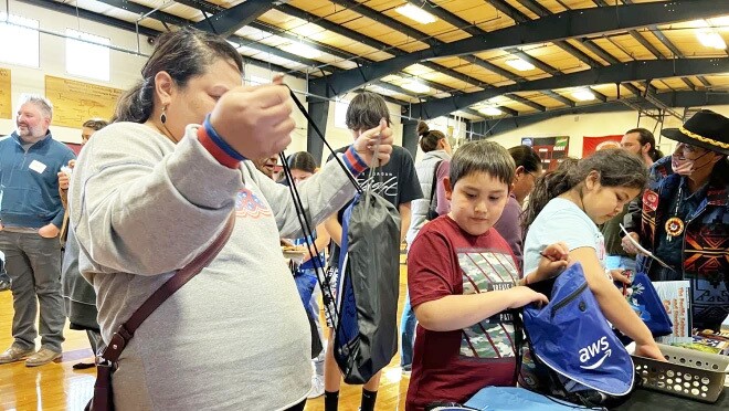 一个女人和男孩保持AWS背包在AWS赞助捐款。