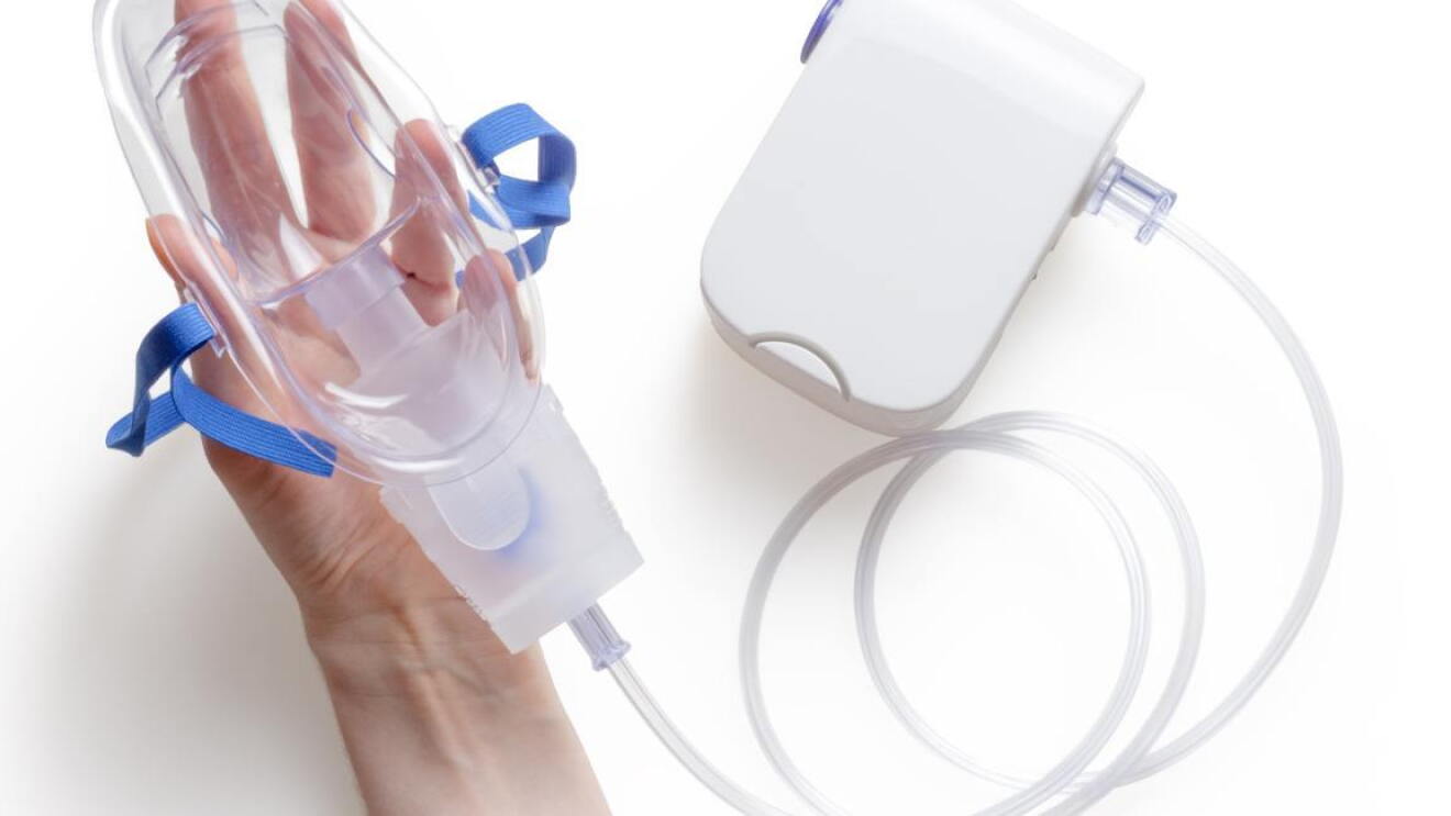 A hand holding an oxygen mask