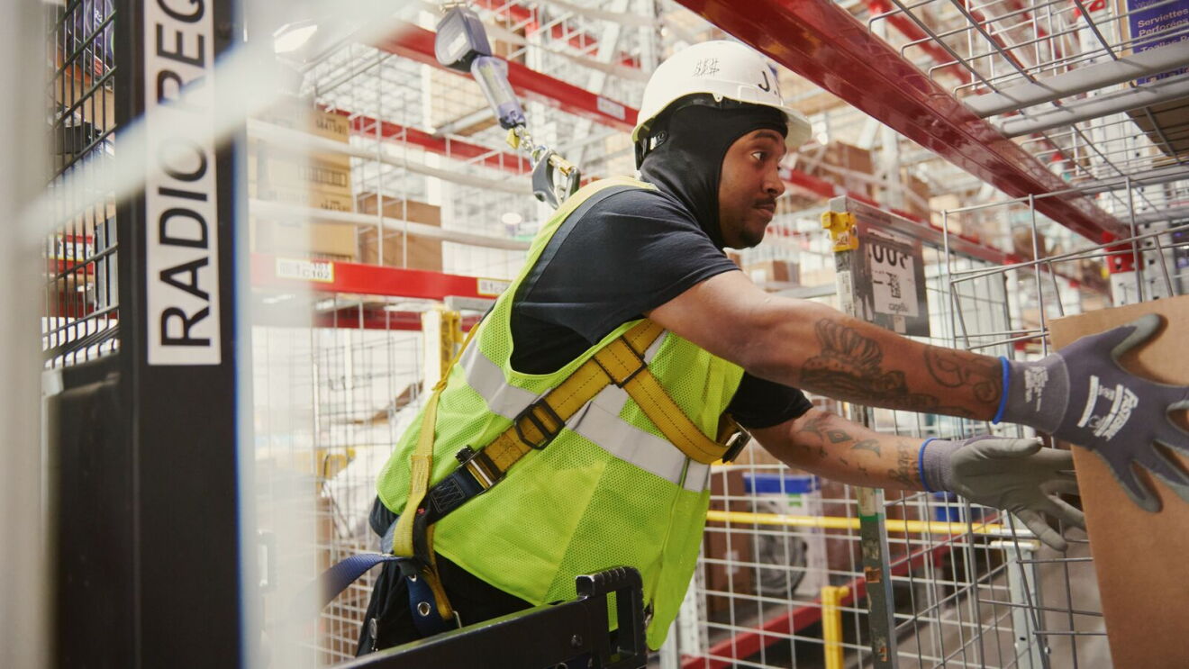 An Amazon team member loads boxes in safety gear at Missouri fulfillment center, SMO1.
