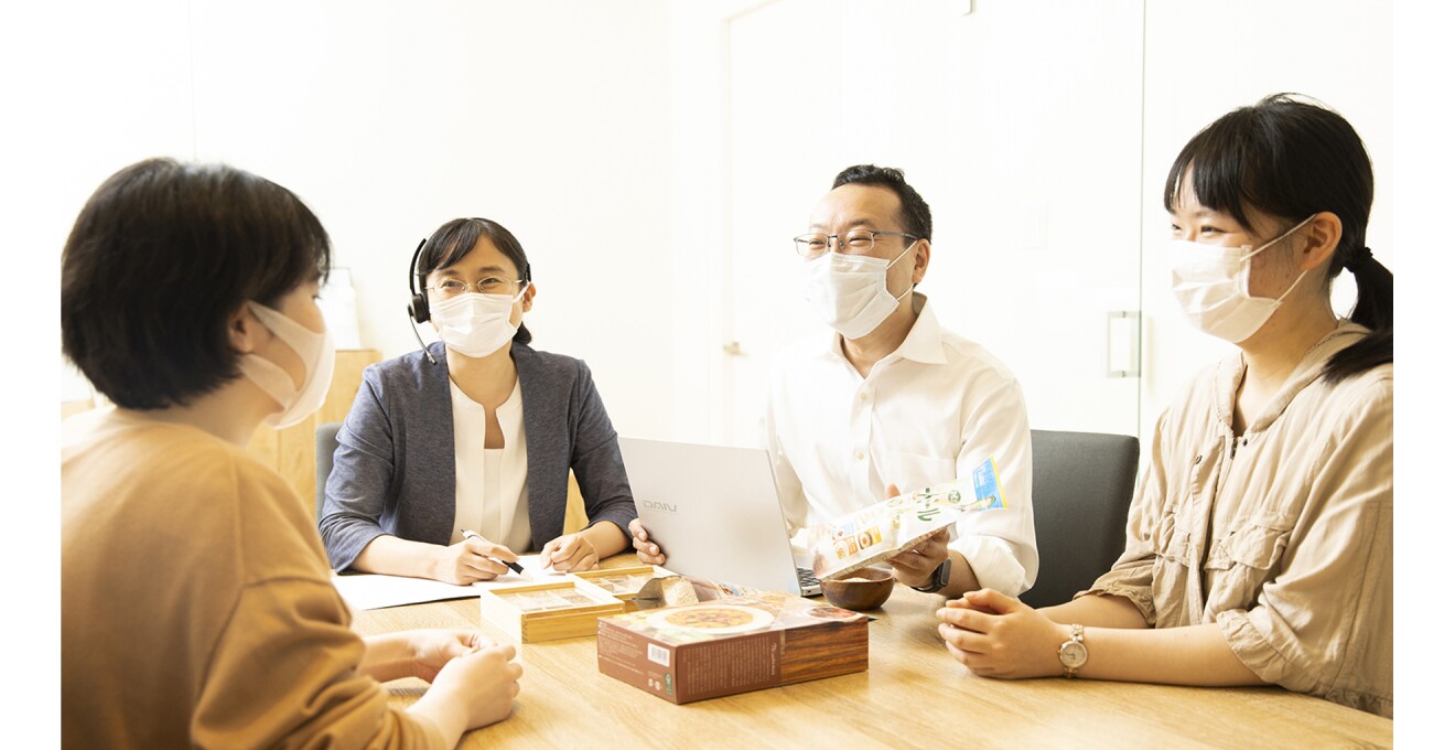 社員と商品を囲んでミーティングしている写真