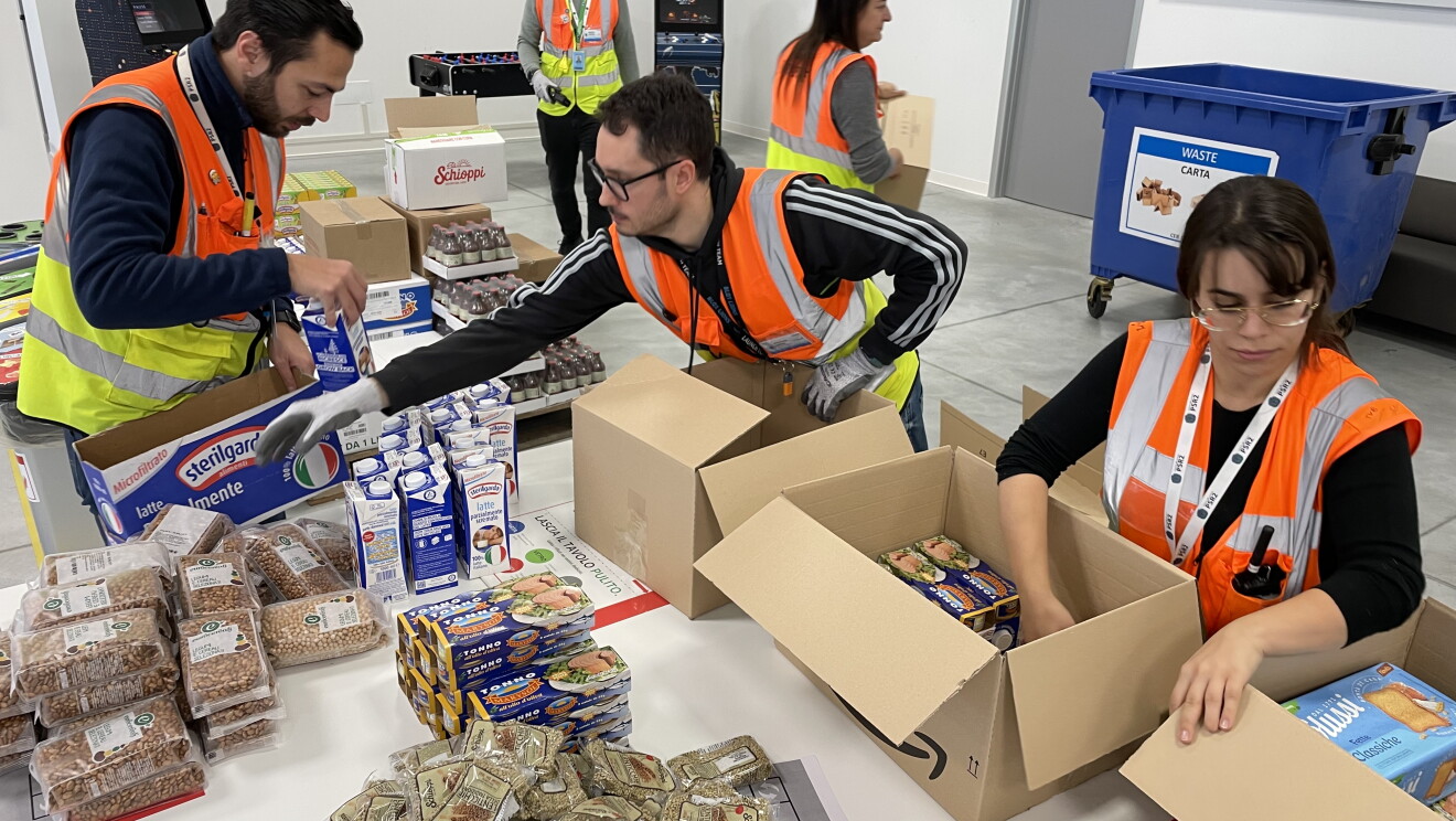 Dipendenti Amazon preparano pacchi alimentari per la donazione natalizia