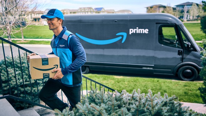 Amazon Prime送货司机走的步骤提供一个包'送货车在后台。