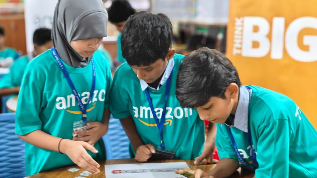 Students huddle around a table working on a task