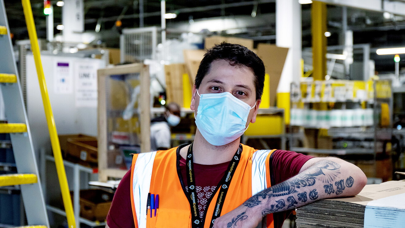 LCY2 - David Gonzalez wearing a facemask and hi-vis jacket in a fulfilment centre