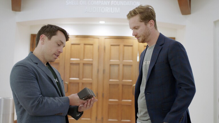 A photo of two students talking in a hallway.