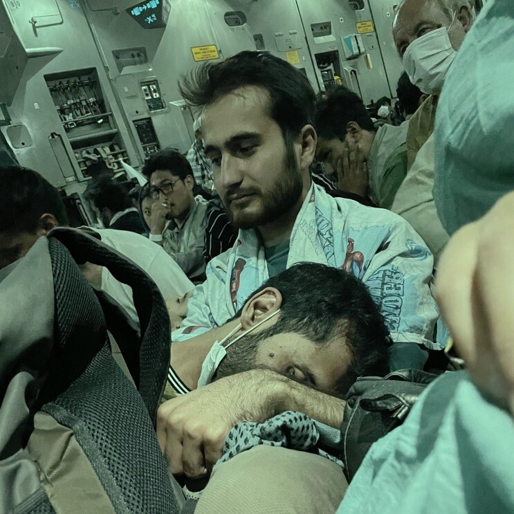 A photo of refugees sitting in a U.S. Army cargo plane, as they evacuated Afghanistan.