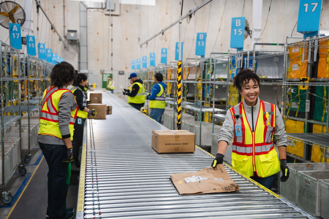 amazon employee in warehouse with packages