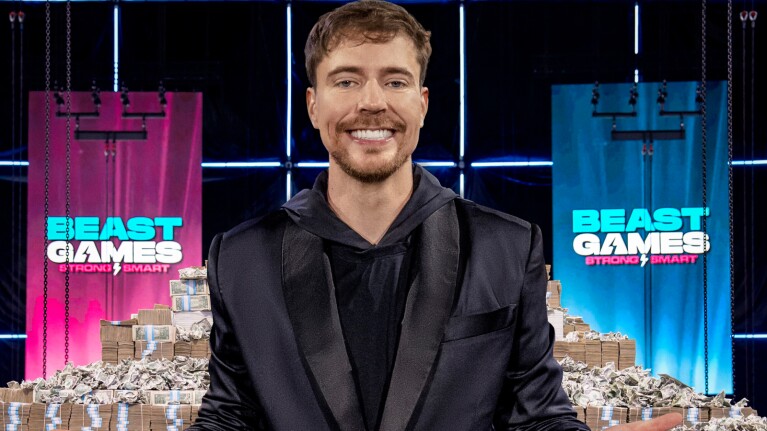 Mr Beast smiling in front of Beast Games logo and stacks of cash