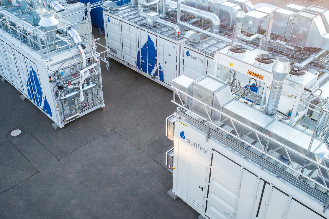 El sistema blanco del especialista en electrólisis de Dresde Sunfire al aire libre. Containers de color blanco con una gota de color azul dibujada en el lateral. 