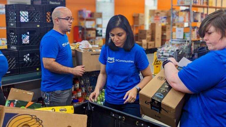 Mishtee Chatterjee的照片,一个AWS数据中心基础设施业务主管,和另外两个亚马逊员工志愿者捐赠的食品进行排序。