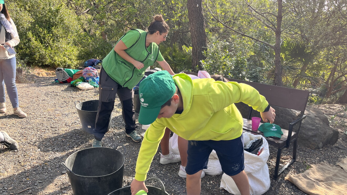 Niño con cubo Cascos Verdes hace bolas de semillas
