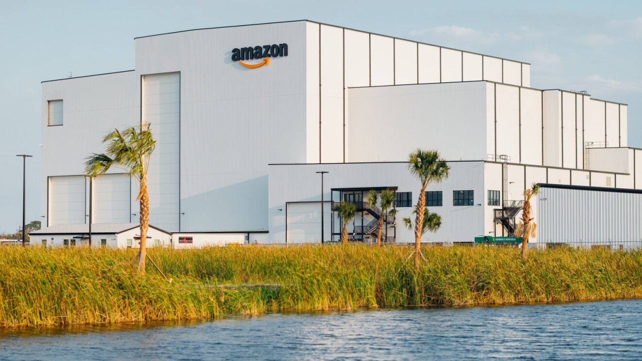 Amazon Leo facility with palm trees near water's edge