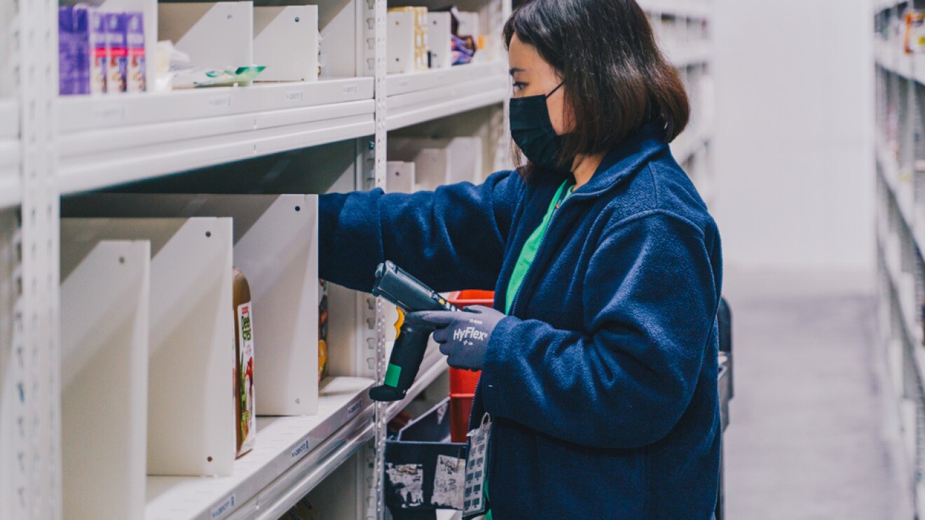 An employee scanning product codes within the chiller in the Amazon Fresh fulfillment centre