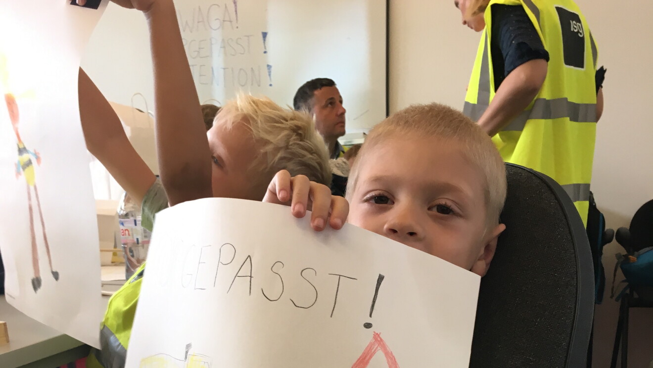 The drawing of a student that says Gepasst! with red exclamation point in a triangle and yellow robot. 
