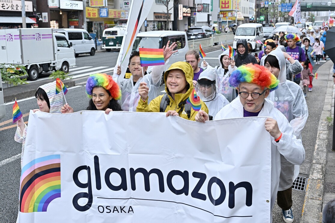 雨の中、大阪の街をパレードするglamazon Osakaのメンバー