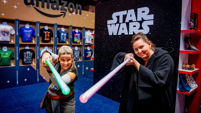 两个女人拿着光剑微笑着对着相机拍照