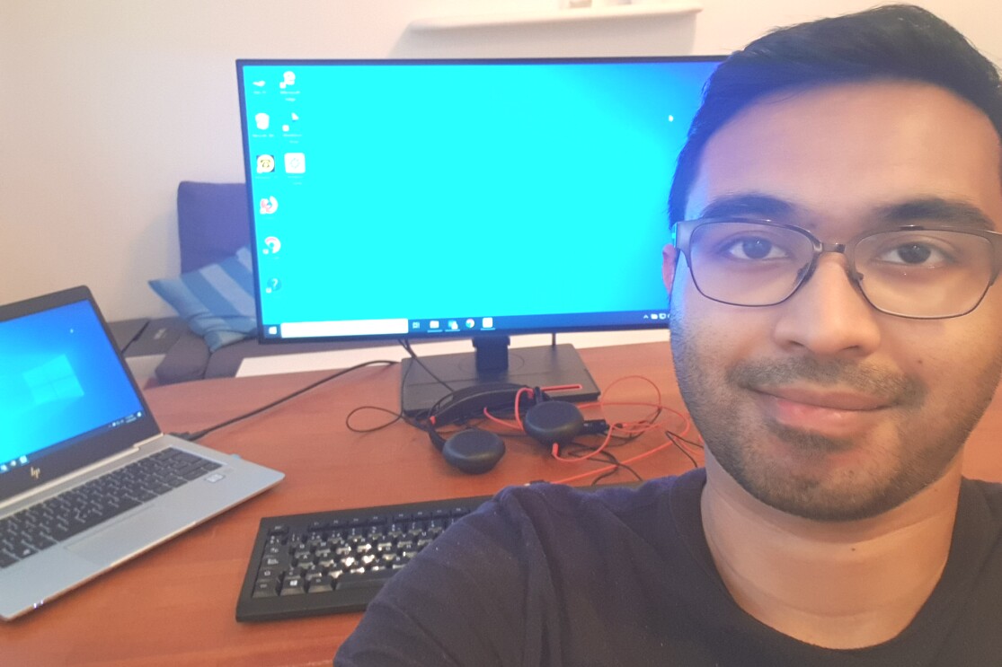 Selfie photo of a man sitting in front of a desk with a computer on it.