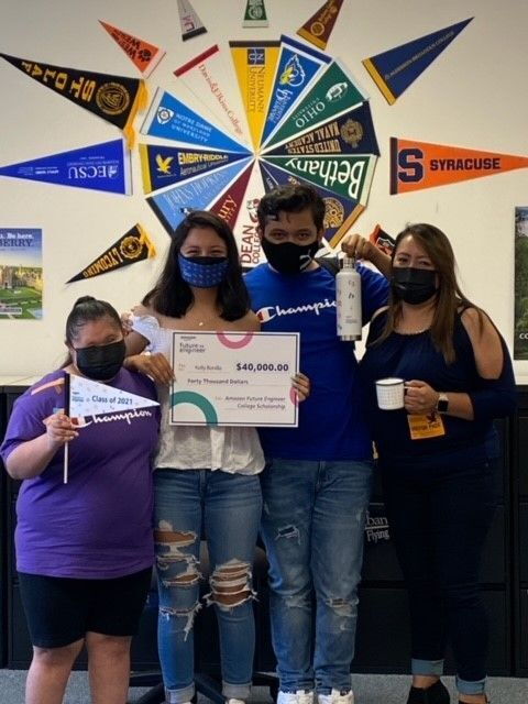 An image of an Amazon Future Engineer scholarship recipient with her family. She is holding check for the scholarship.