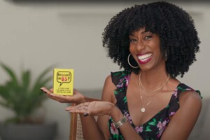 A woman holds a box while smiling. The box of cards reads "Brilliant or BS"