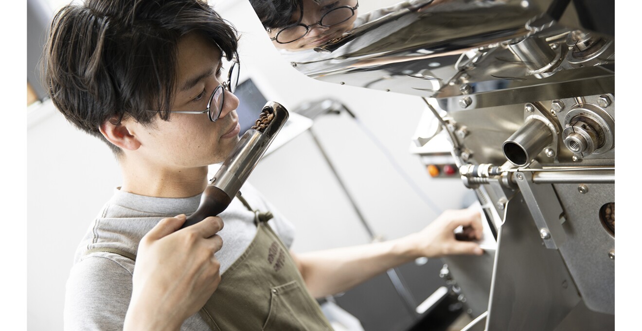焙煎機から取り出した豆の香りをチェックする焙煎士さんの写真
