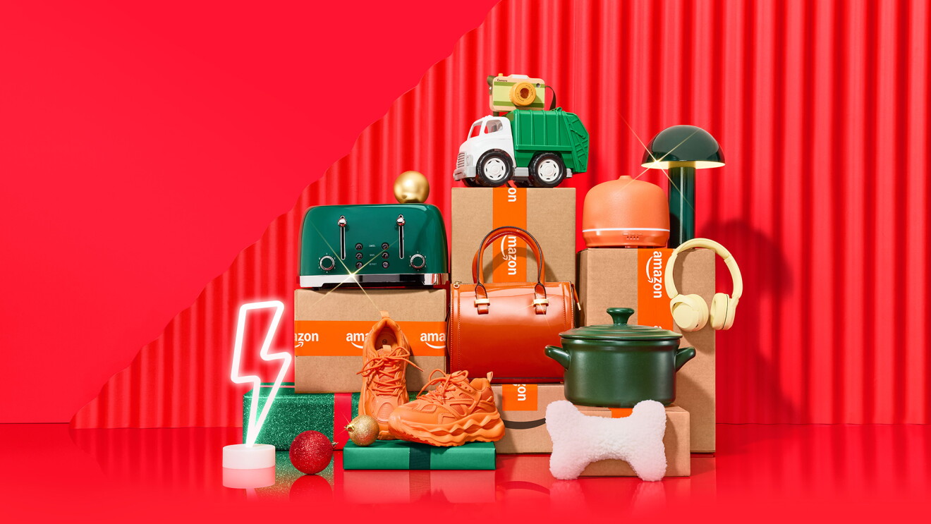 Colorful stack of Amazon packages and products against bright red background
