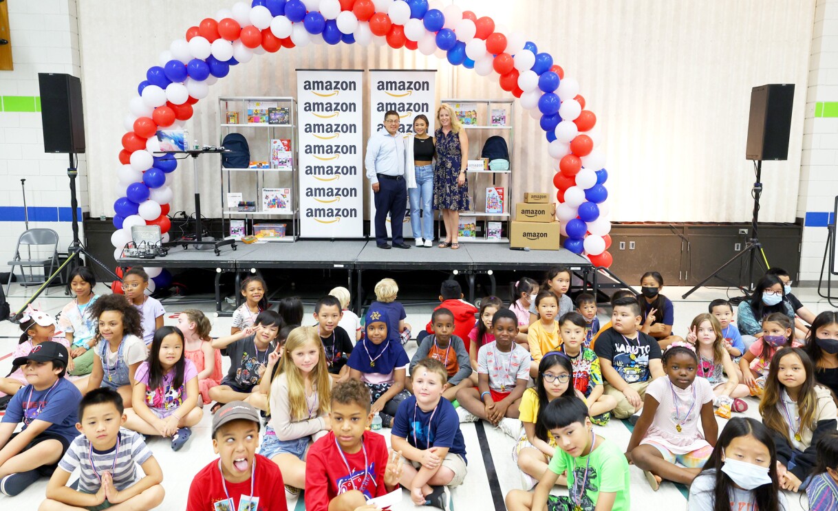 Suni Lee poses with students at an elementary school.